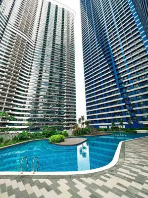 a swimming pool in the middle of two tall buildings at Air Residences - 1Bedroom Unit with Balcony - Wifi & Netflix in Manila