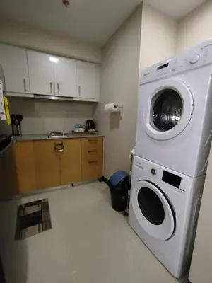 a kitchen with a washing machine in a room at Uptown Parksuites Tower 1 BGC in Manila