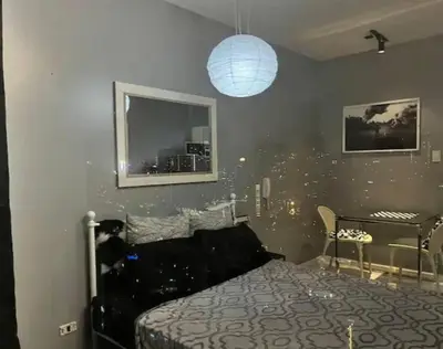 a bedroom with a black bed and a window at Makati - Sleeps 2 - Pool - Cinema - Gym - Garden in Manila