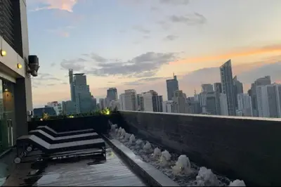 a group of birds sitting on a balcony with a city skyline at Makati - Sleeps 2 - Pool - Cinema - Gym - Garden in Manila