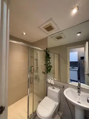 a bathroom with a toilet and a shower and a sink at Makati - Sleeps 2 - Pool - Cinema - Gym - Garden in Manila