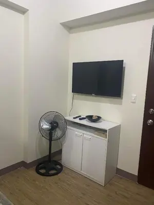 a room with a fan and a flat screen tv at staycation affordable alabang in Manila