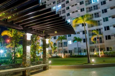 a large building with a bench and palm trees at staycation affordable alabang in Manila