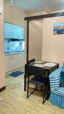 a kitchen with a table and a chair in a room at staycation affordable alabang in Manila