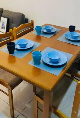 a wooden table with blue bowls and plates on it at Lyndon at Sea Residences, SMDC MOA Complex, Pasay City, Philippines in Manila