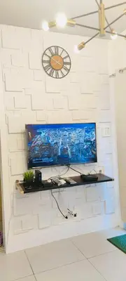 a flat screen tv on a white brick wall at Lyndon at Sea Residences, SMDC MOA Complex, Pasay City, Philippines in Manila