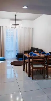 a living room with a table and chairs at Lyndon at Sea Residences, SMDC MOA Complex, Pasay City, Philippines in Manila