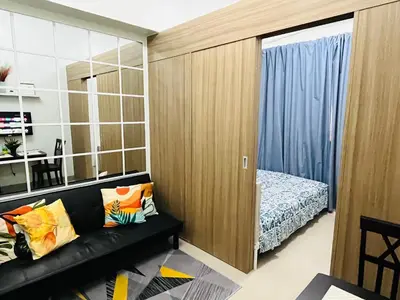 a living room with a black couch and a bed at Staycation by Janeil at Shore 2 Residences SMDC, MOA Complex, Pasay City, Philippines in Manila
