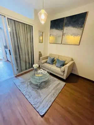 a living room with a couch and a glass table at Stylish 1 bedroom condo with pool view and Fast WIFI in Manila