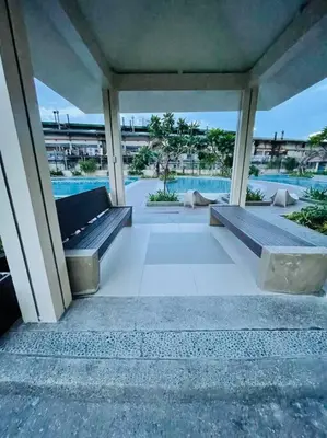a porch with two benches and a swimming pool at Stylish 1 bedroom condo with pool view and Fast WIFI in Manila