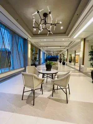 a lobby with a table and chairs and a chandelier at Stylish 1 bedroom condo with pool view and Fast WIFI in Manila