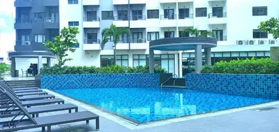 a swimming pool in front of a building at OneTiago Staycation - Spring Residences Paranaque in Manila