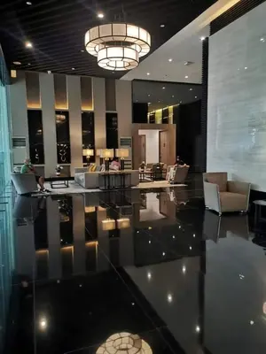 a lobby with couches and a chandelier in a building at Cruz Air Residences in Manila