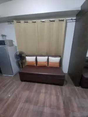 a couch in a room with a curtain at Cruz Air Residences in Manila