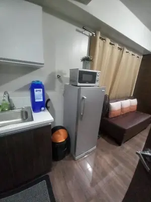 a small kitchen with a microwave on top of a refrigerator at Cruz Air Residences in Manila