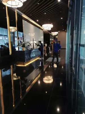 a man taking a picture in a lobby of a building at Cruz Air Residences in Manila