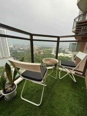 three chairs and a table on a balcony at The Radiance Manila Bay - Modern 1-Bedroom Condo with View in Manila