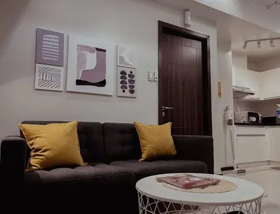 a living room with a black couch and a table at The Radiance Manila Bay - Modern 1-Bedroom Condo with View in Manila