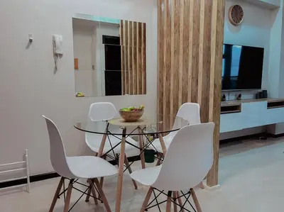 a dining room with a glass table and white chairs at The Radiance Manila Bay - Modern 1-Bedroom Condo with View in Manila
