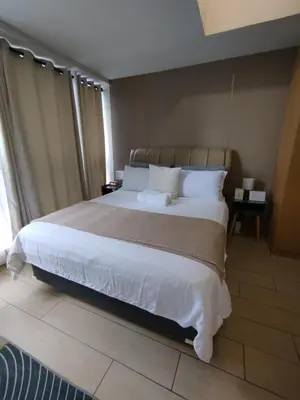 a bedroom with a large bed with white sheets and pillows at Cozy 1BR UPTOWN PARKSUITES Tower1 BGC in Manila