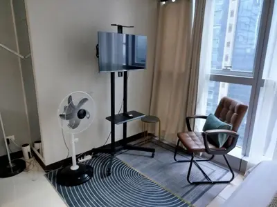 a room with a tv and a chair and a fan at Cozy 1BR UPTOWN PARKSUITES Tower1 BGC in Manila
