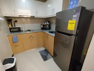 a kitchen with a stainless steel refrigerator and cabinets at Cozy 1BR UPTOWN PARKSUITES Tower1 BGC in Manila