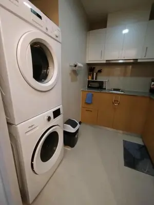 a small kitchen with a washer and dryer in it at Cozy 1BR UPTOWN PARKSUITES Tower1 BGC in Manila
