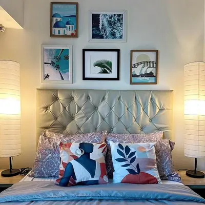 a bedroom with a bed with pillows and pictures on the wall at Acqua Private Residence Livingstone Tower Condo Unit with Free Wifi in Manila