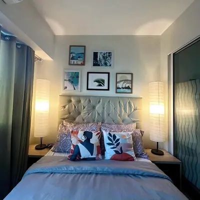a bedroom with a large bed with pillows and two lamps at Acqua Private Residence Livingstone Tower Condo Unit with Free Wifi in Manila