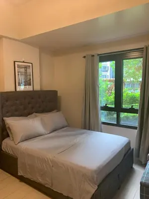 a bed in a bedroom with a large window at Salamat Place Original in Manila