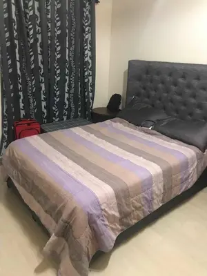 a bed with a blanket and a red suitcase at Salamat Place Original in Manila