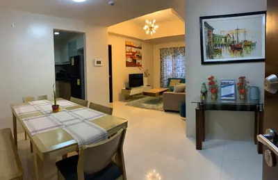 a dining room and living room with a dining table at Salamat Place Original in Manila