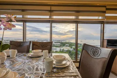 a dining room with a table and chairs and a large window at The Radiance Manila Bay in Manila