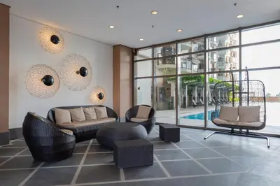 a living room with a couch and chairs and windows at The Radiance Manila Bay in Manila