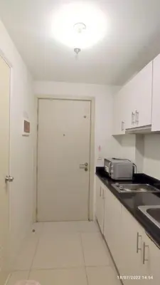 a white kitchen with a door and a counter top at Jazz Residences (Destina Stays)Makati, Metro Manila in Manila