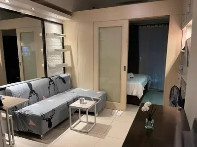 a living room with a couch and a bedroom at Netflix, Destina Stays at Jazz Residences Makati, MetroManila in Manila