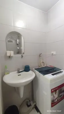 a white bathroom with a sink and a mirror at Netflix, Destina Stays at Jazz Residences Makati, MetroManila in Manila