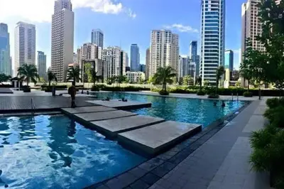 a large swimming pool with a city in the background at Netflix, Destina Stays at Jazz Residences Makati, MetroManila in Manila