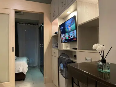 a living room with a flat screen tv in a room at Netflix, Destina Stays at Jazz Residences Makati, MetroManila in Manila