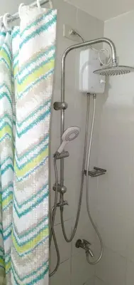 a shower in a bathroom with a striped towel at Jazz Residences by Destina Stays, Makati, Metro Manila in Manila