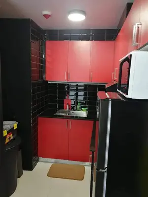 a red kitchen with a sink and red cabinets at Cubao Manhattan Heights Unit 11PQ Tower B, 1BR in Manila