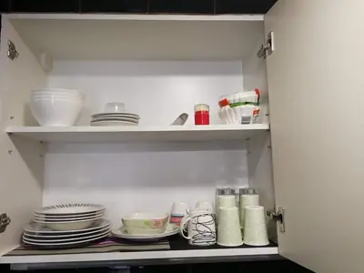 a cupboard filled with plates and bowls and dishes at Cubao Manhattan Heights Unit 11PQ Tower B, 1BR in Manila
