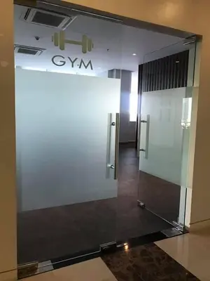 a glass wall in a building with a elevator at Studio at viceroy t4 Florence way in Manila
