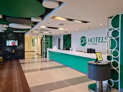 a lobby of a hotel with a reception counter at Go Hotels Otis - Manila in Manila