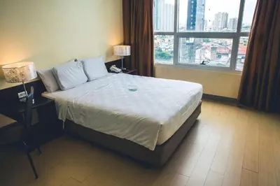 a bedroom with a bed and a large window at Go Hotels Plus Mandaluyong in Manila