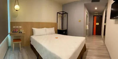 a bedroom with a large white bed and a hallway at Go Hotels Plus Mandaluyong in Manila