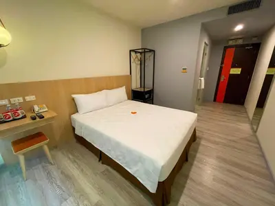 a bedroom with a bed and a table and a door at Go Hotels Plus Mandaluyong in Manila