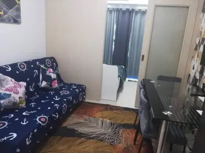 a living room with a couch and a glass table at Alatonplace sea residences in Manila