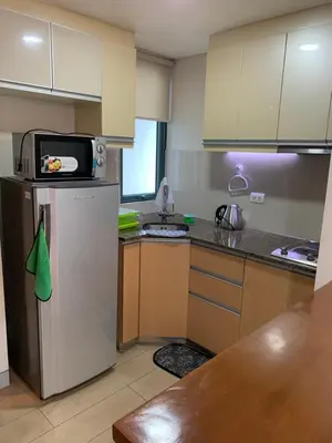 a kitchen with a refrigerator and a microwave at MRMCONDOTEL cluster 1 2H in Manila