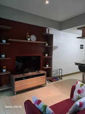 a living room with a flat screen tv at MRMCONDOTEL cluster 1 2H in Manila